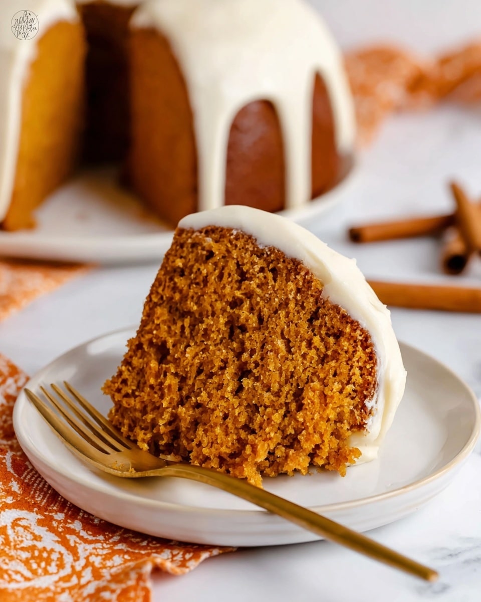 A round bundt cake with one thick layer of light brown cake forms the base, topped with thick, creamy, off-white icing drizzled in large, soft loops that hang down the sides unevenly. The cake sits on a simple white plate, with a few gold forks and cake servers placed beside it on a white marbled surface. In the background, there are some cinnamon sticks and white plates partially visible, with a soft, out-of-focus white and orange cloth adding a cozy touch. The overall scene is bright and clean, highlighting the cake's texture and creamy topping. photo taken with an iphone --ar 4:5 --v 7