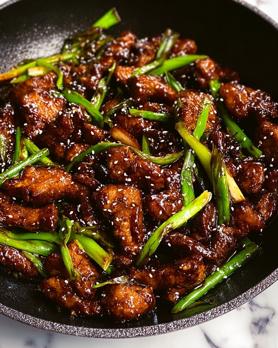 The image shows a close-up of a black pan filled with several unevenly shaped pieces of dark brown glazed chicken coated in a shiny sauce. Bright green spring onion stalks are mixed in evenly among the chicken pieces, adding contrast. White sesame seeds are sprinkled all over the dish, sitting on top of the chicken and green onions. The pan rests on a white marbled surface. photo taken with an iphone --ar 4:5 --v 7