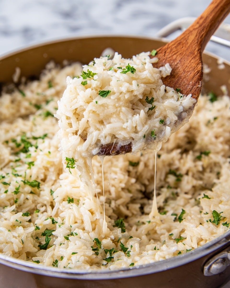 The image shows a close-up of cooked white rice mixed with melted cheese, giving it a slightly sticky texture. The rice is light cream in color, with small green parsley leaves scattered evenly on top, adding a touch of freshness and color contrast. A wooden spoon lifts a portion of the rice, showing some stretched melted cheese strands connecting the spoonful to the rest in a large brown pot. The pot holds a dense layer of this cheesy rice mixture, with some parsley pieces visible on the surface. The background surface is a white marbled texture. photo taken with an iphone --ar 4:5 --v 7