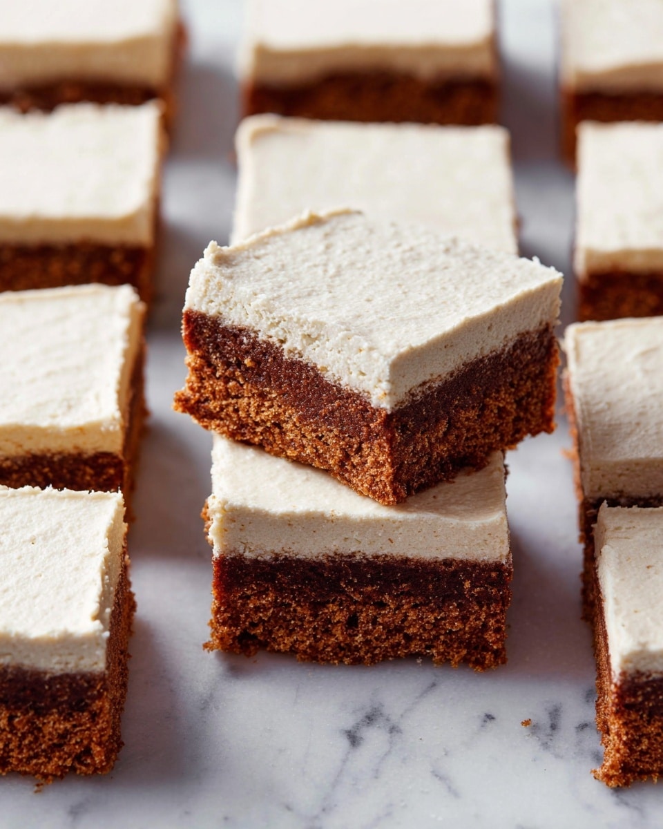 The image shows several square slices of a two-layer dessert arranged closely together on a white marbled surface. Each piece has a thick, moist-looking brown base with a slightly crumbly texture, topped with a smooth, creamy off-white layer that looks soft and lightly whipped. The creamy layer is evenly spread, covering the entire top of each slice. One slice is raised above the others, showing a clear side view of the two distinct layers with the brown base below and the off-white cream on top. photo taken with an iphone --ar 4:5 --v 7