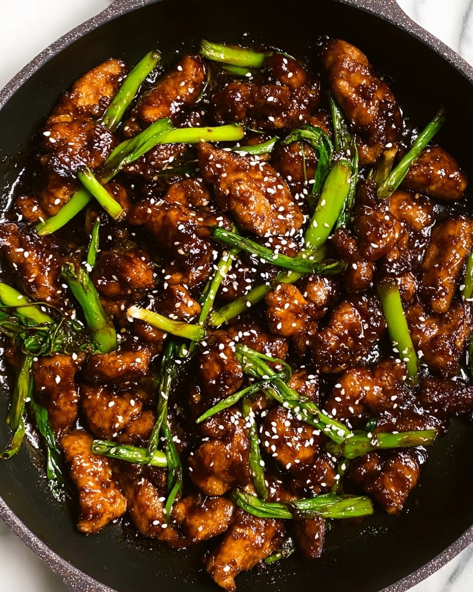The image shows a close-up of a wok filled with dark brown sticky glazed chicken pieces mixed with bright green scallion stalks. The chicken pieces look tender and coated with a shiny sauce. Small white sesame seeds are sprinkled all over, adding texture and a little contrast. The black wok has a sturdy look with slight texture on the edges, and the dish fills the pan evenly, showing a mix of thick, glossy, brown-coated chicken and fresh green vegetables. The background is a white marbled texture. photo taken with an iphone --ar 4:5 --v 7