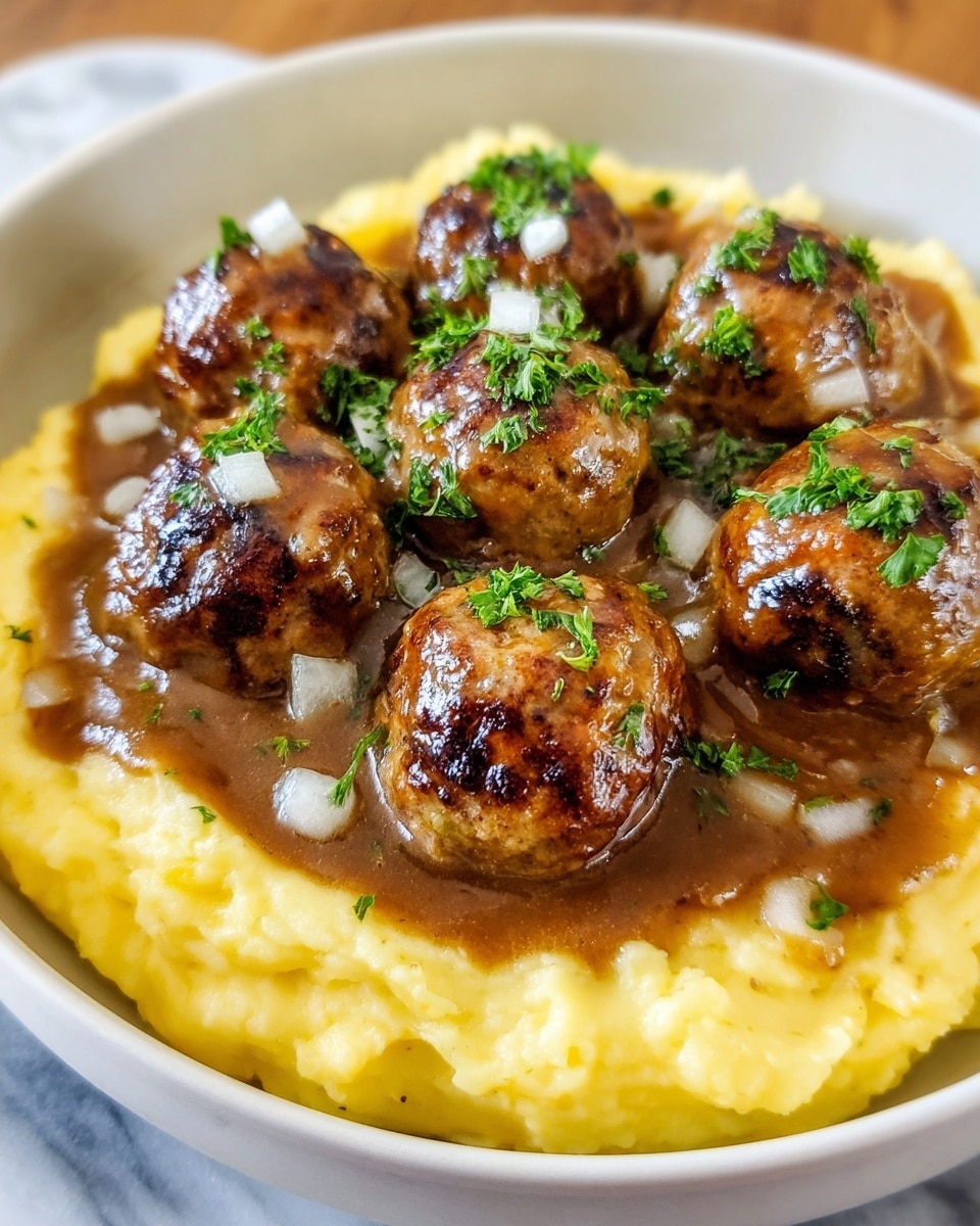 A white bowl filled with a base layer of creamy, pale yellow mashed potatoes that have a smooth and slightly chunky texture. On top sits a rich layer of brown gravy with visible small onion slices mixed in, partially soaking into the mashed potatoes. Arranged in a circle and stacked slightly in the middle are seven golden-brown meatballs with a juicy and slightly charred surface. The dish is garnished with chopped fresh green herbs scattered over the meatballs and gravy. The whole bowl is placed on a white marbled surface. photo taken with an iphone --ar 4:5 --v 7
