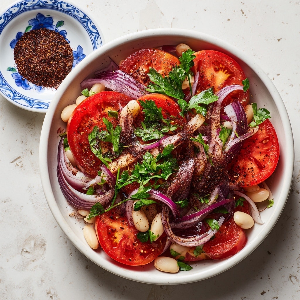A clear glass bowl filled with a colorful salad that has three main layers mixed together: bright red tomato wedges, thin slices of purple onion, and small white beans, all sprinkled with chopped green parsley. The tomato pieces are juicy with a smooth texture, while the onion slices add a crisp look, and the beans add a soft, round contrast. The salad is lightly coated with seasoning visible as tiny dark specks. The bowl is placed on a white marbled surface, creating a clean and fresh setting. photo taken with an iphone --ar 4:5 --v 7