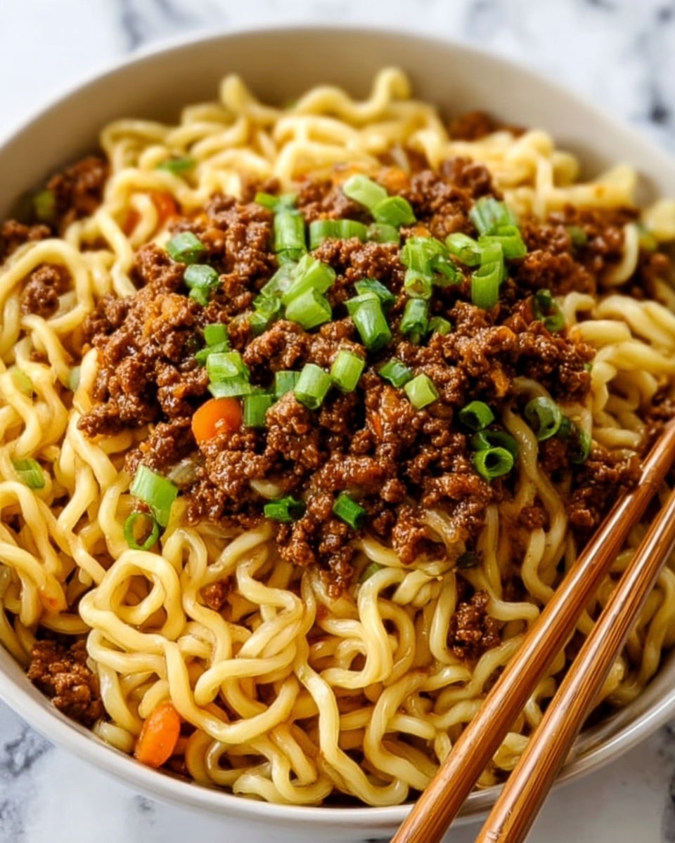 A close-up view of a bowl filled with thick, curly noodles at the bottom, light yellow in color and slightly glossy from sauce. On top of the noodles is a layer of finely ground cooked meat, brown and moist, covering most of the noodles. Small pieces of orange carrot strips and bright green chopped scallions are scattered over the meat, adding color contrast. A pair of wooden chopsticks is seen resting on the side of the bowl. The bowl is white and stands on a white marbled surface. photo taken with an iphone --ar 4:5 --v 7