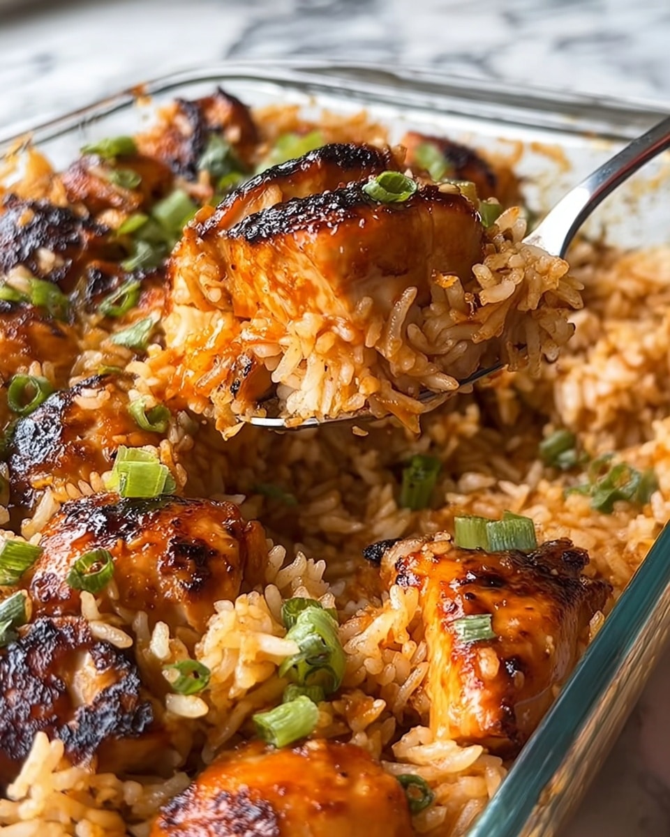 The image shows a close-up of a glass baking dish filled with two main layers: a base of cooked white rice with a slightly sticky texture, and a top layer of grilled chicken pieces coated in a shiny, dark orange glaze. Scattered over the top are small green chopped herbs, adding contrast. A fork lifted from the dish holds a piece of chicken with a visible tender white interior and some rice clinging to it, with a shiny glaze drip falling down. The dish rests against a blurred kitchen background with a white marbled surface barely visible. photo taken with an iphone --ar 4:5 --v 7